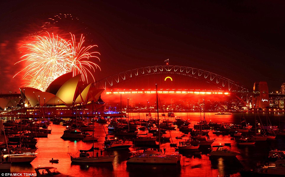 AUSTRALIA: A red hue lights up the sky over the Sydney Opera House. More than a million people gathered to watch and then celebrate 2012