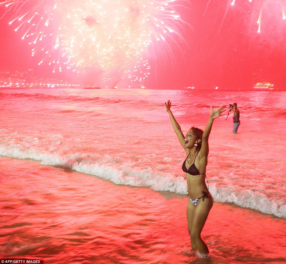 BRAZIL: As fireworks go off on the Copacabana, this new year reveller celebrates the start of 2012 in the sea. Over three million people attended the New Year's Eve festivities in Rio