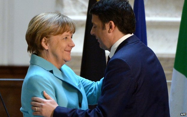 Italian Prime Minister Matteo Renzi hugs German Chancellor Angela Merkel during a joint press conference in the Galleria dell'Accademia in central Florence on 23 January 2015