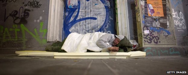 A homeless man sleeps in a doorway on the streets of Athens on 21 January 2015